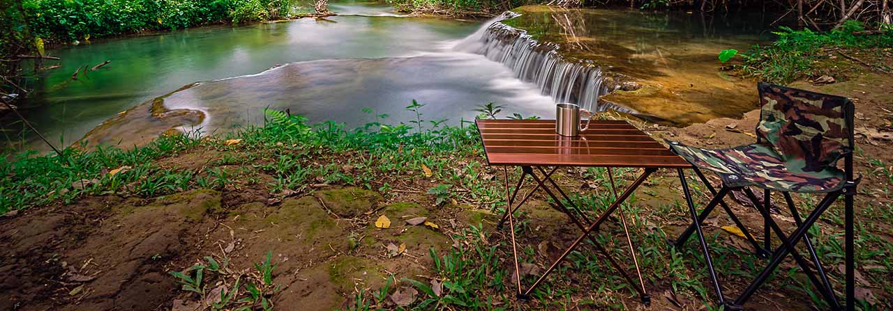 mesa e cadeira próximas a uma cachoeira